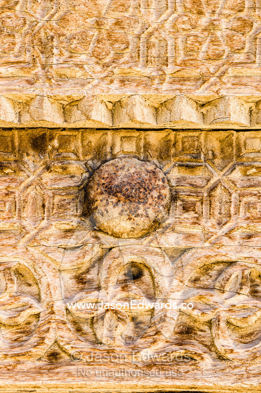 Ornate carving in the timber door frame of a home in an ancient desert village. Ibra, Ash Sharqiyah Region, Sultanate of Oman.