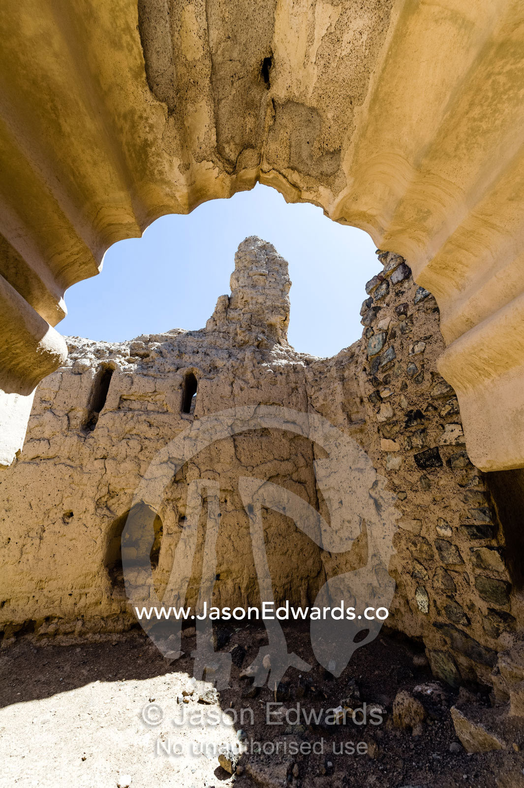 Ornate scalloped stone and mudbrick archways in an abandoned village in the desert. Ibra, Ash Sharqiyah Region, Sultanate of Oman.