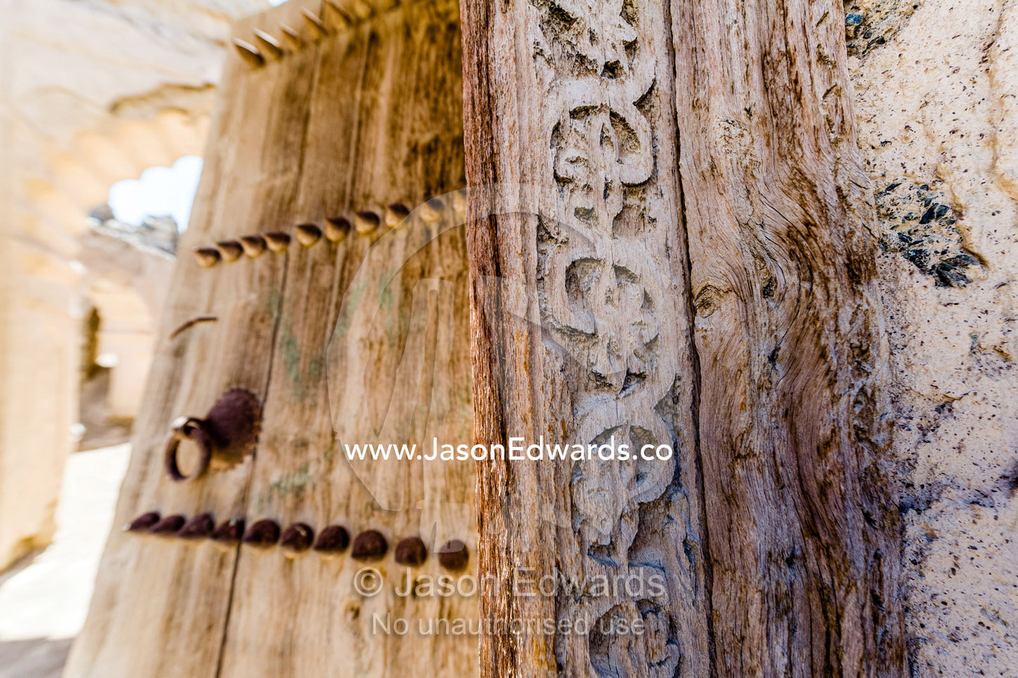 Ornate carving in the timber door frame of a home in an ancient desert village. Ibra, Ash Sharqiyah Region, Sultanate of Oman.