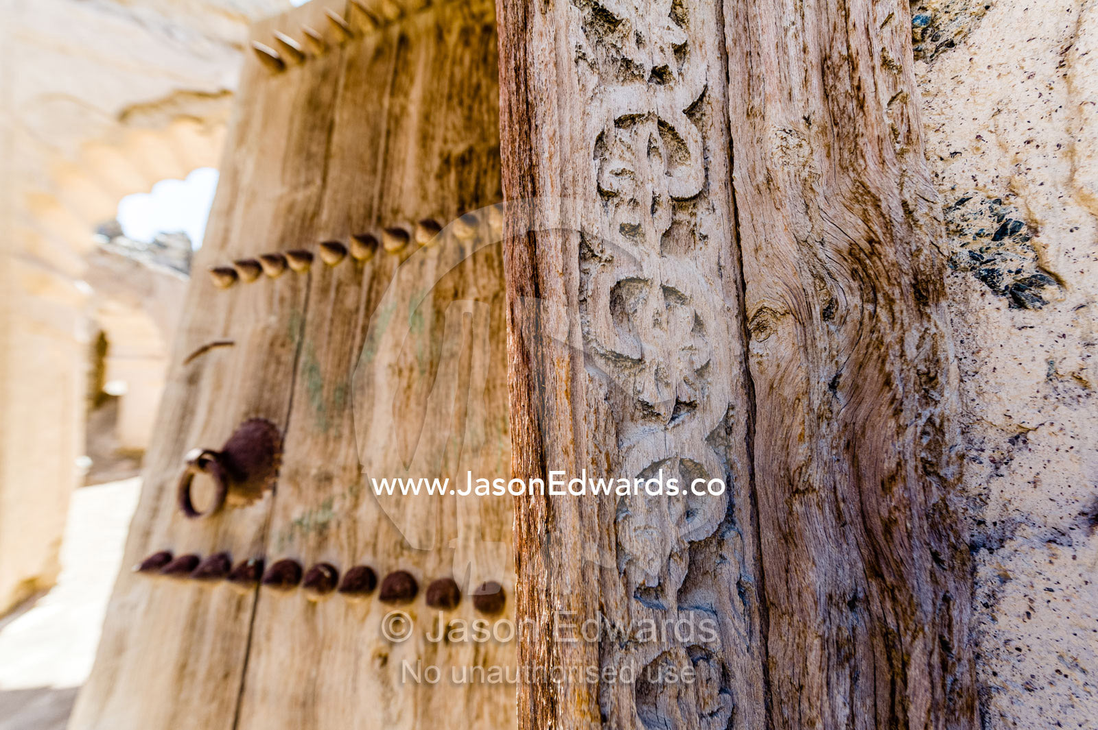 Ornate carving in the timber door frame of a home in an ancient desert village. Ibra, Ash Sharqiyah Region, Sultanate of Oman.
