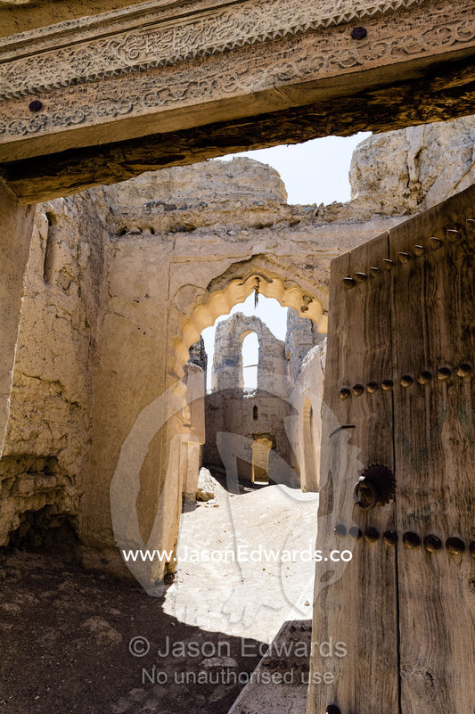 The carved timber lintel and doorway of a home in an ancient desert village. Ibra, Ash Sharqiyah Region, Sultanate of Oman.