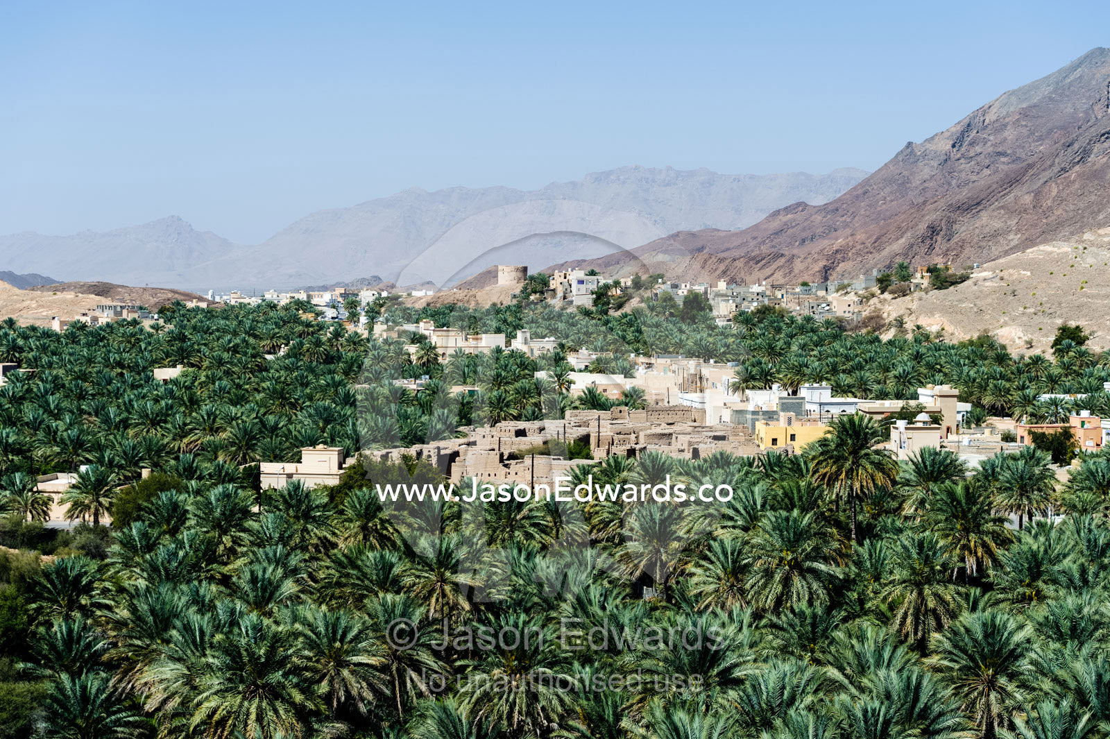 An ancient village surrounded by an irrigated plantation of date palms in a desert valley. Barkat Al Mouz, Sultanate of Oman.