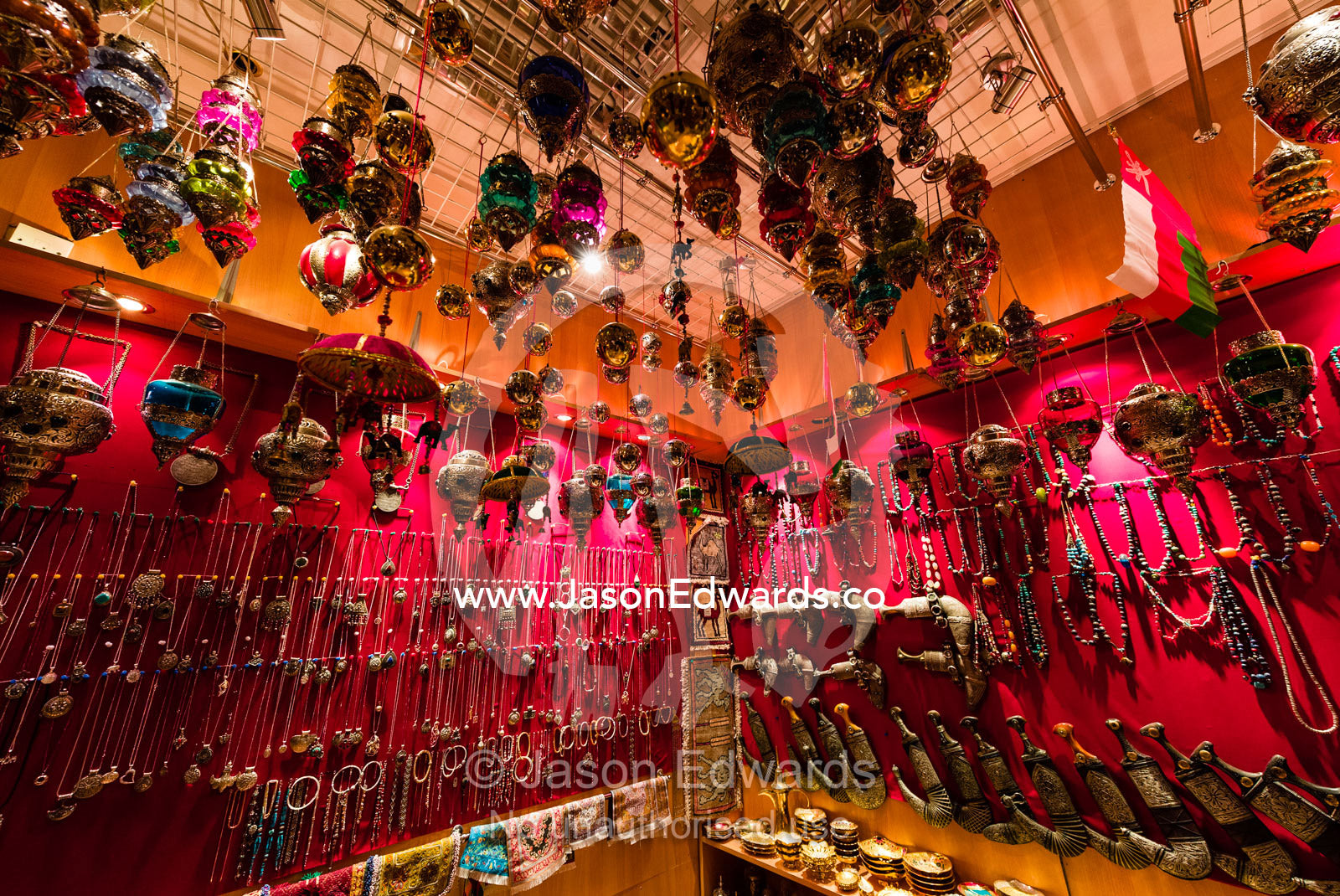 A display of silver bracelets, necklaces, jewellery and khanjar knives for sale in a souq. Mutrah Souq, Muscat, Sultanate of Oman.