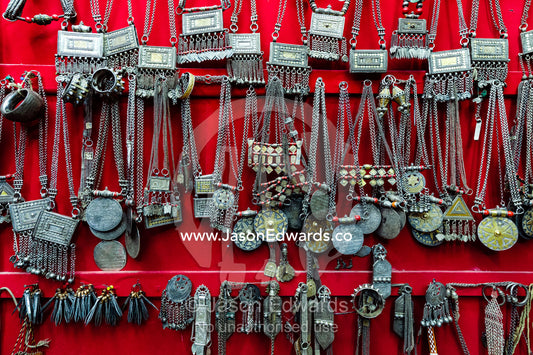 A wall displaying silver necklaces for sale in a souq. Mutrah Souq, Muscat, Sultanate of Oman.