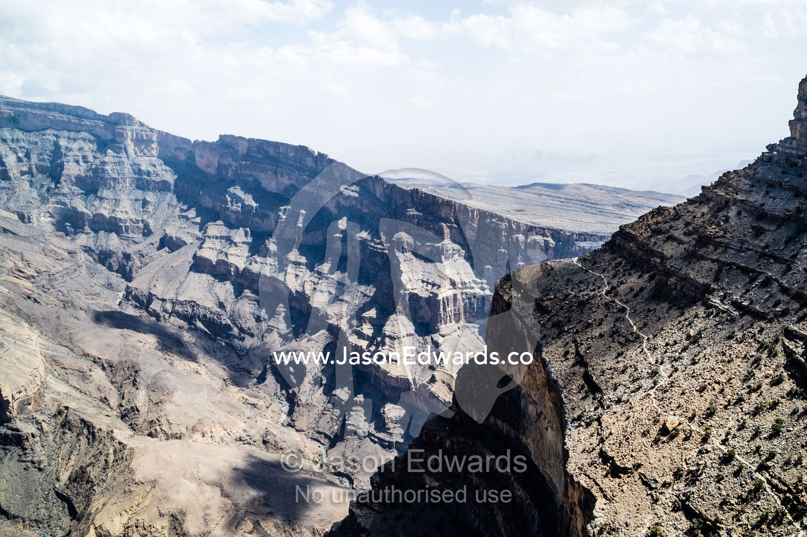Sheer cliff walls and terraces carved by erosion in a massive desert canyon. Wadi Ghul, Jebel Shams, Al Hajar Mountains, Sultanate of Oman.