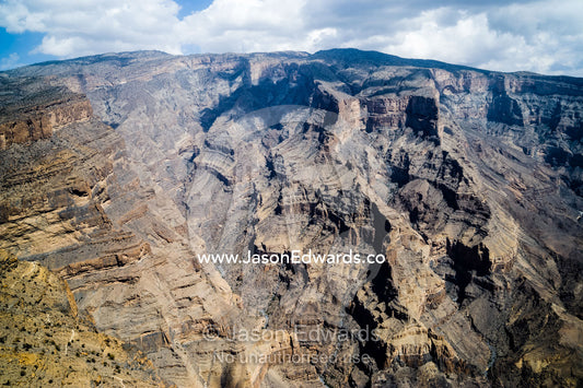 Sheer cliff walls and terraces carved by erosion in a massive desert canyon. Wadi Ghul, Jebel Shams, Al Hajar Mountains, Sultanate of Oman.