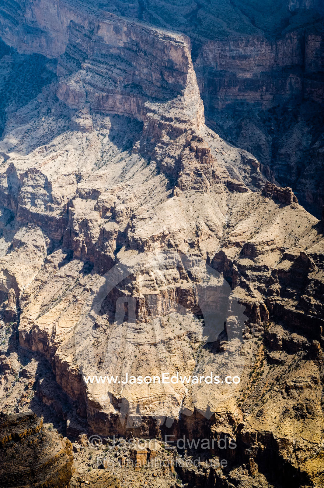 Sheer cliff walls and terraces carved by erosion in a massive desert canyon. Wadi Ghul, Jebel Shams, Al Hajar Mountains, Sultanate of Oman.