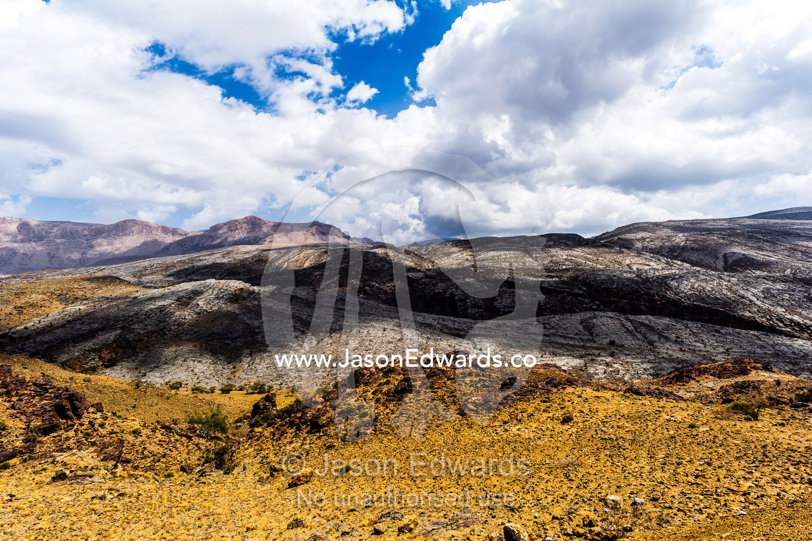 The arid rocky slopes of a prehistoric and volcanic desert landscape. Jebel Shams, Al Hajar Mountains, Sultanate of Oman.