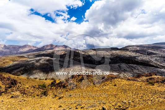 The arid rocky slopes of a prehistoric and volcanic desert landscape. Jebel Shams, Al Hajar Mountains, Sultanate of Oman.