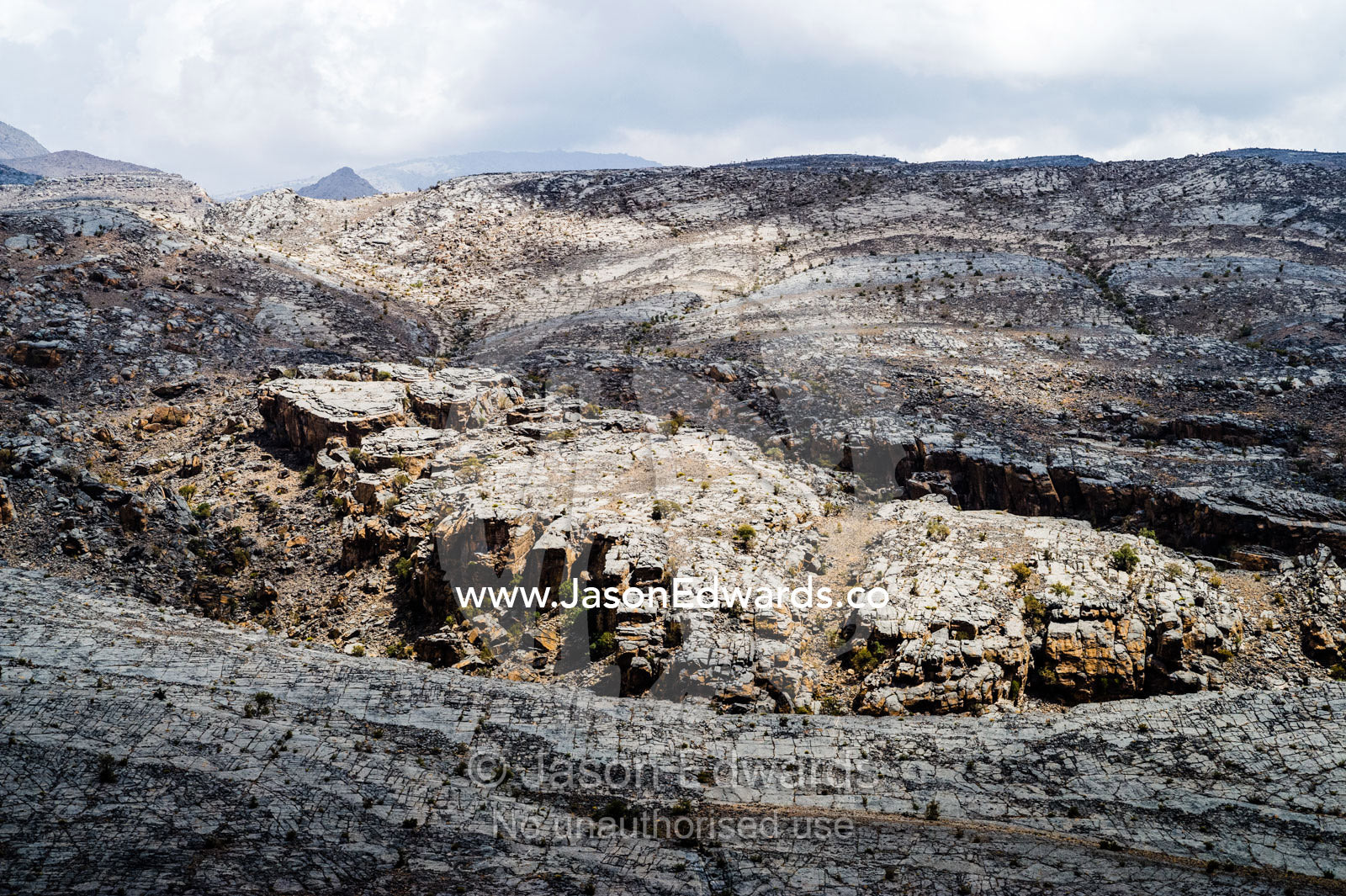 The arid rocky slopes of a prehistoric and volcanic desert landscape. Jebel Shams, Al Hajar Mountains, Sultanate of Oman.