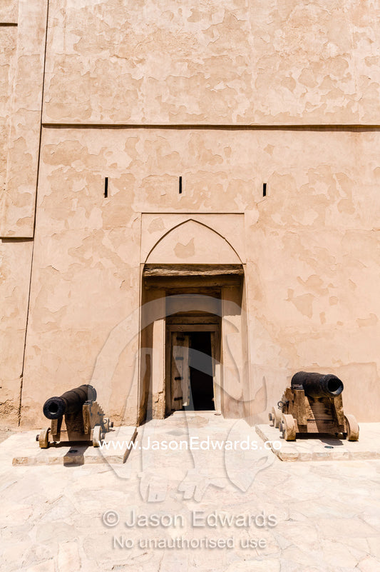 Cannons guard a door in the sheer walls of Jabrin Fort. Jabrin Fort, Ad Dakhiliyah Governorate, Sultanate of Oman.
