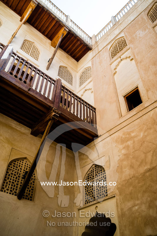 Timber balconies overlook latticed windows and a shaded courtyard in an ancient fort. Jabrin Fort, Ad Dakhiliyah Governorate, Sultanate of Oman.