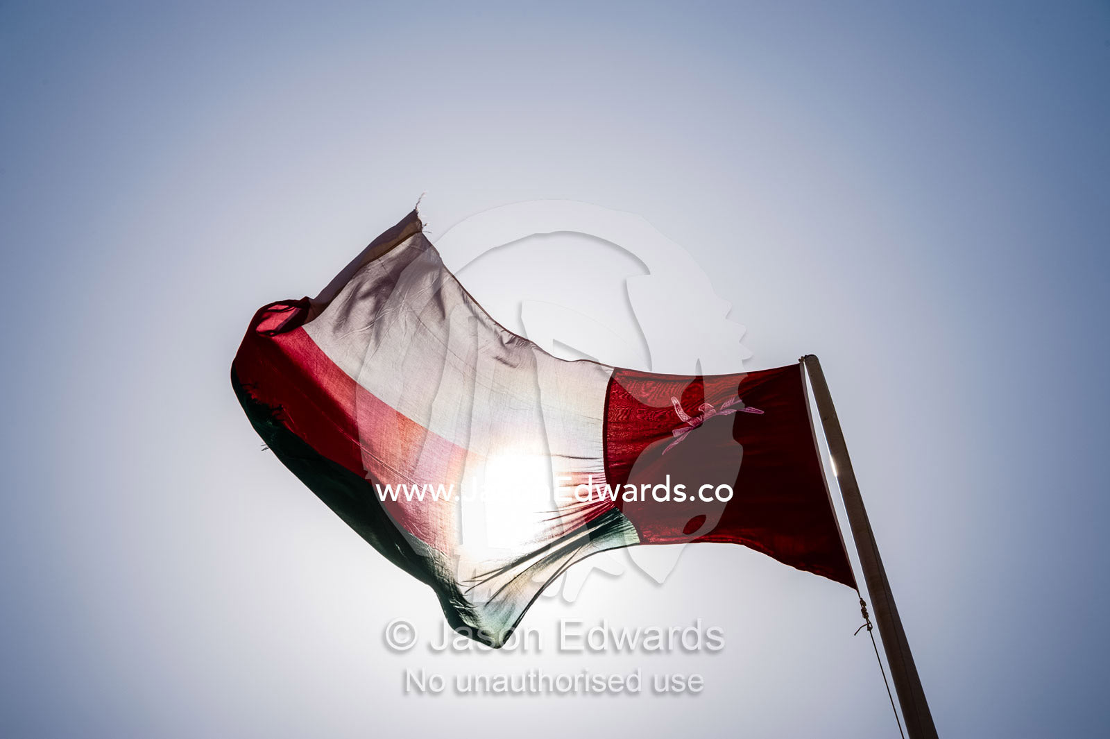 The flag of Oman flapping beneath the desert sun. Jabrin Fort, Ad Dakhiliyah Governorate, Sultanate of Oman.