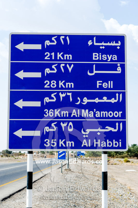 A highway sign showing the distances to locations in Arabic. Jabrin Fort, Ad Dakhiliyah Governorate, Sultanate of Oman.