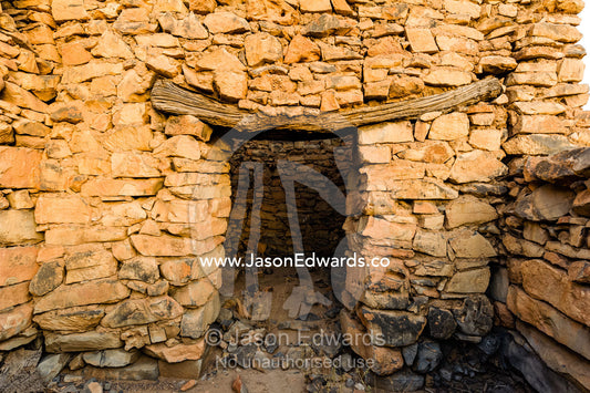 An ancient handmade stone building wall and timber door lintel in an abandoned desert village. Wadi Nakhar, Al Hamra, Ad Dakhiliyah Region, Sultanate of Oman.