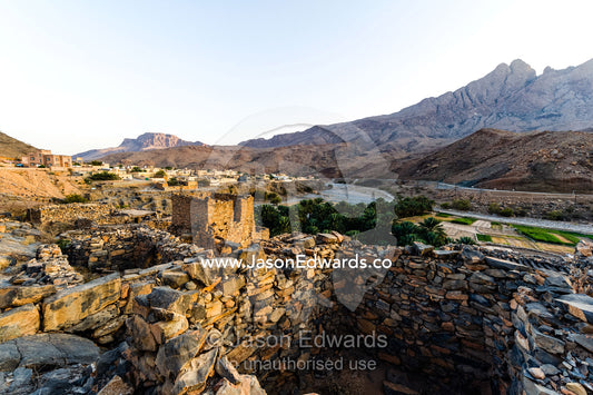 Ancient handmade stone buildings, shops and homes line a street in an abandoned village. Wadi Nakhar, Al Hamra, Ad Dakhiliyah Region, Sultanate of Oman.