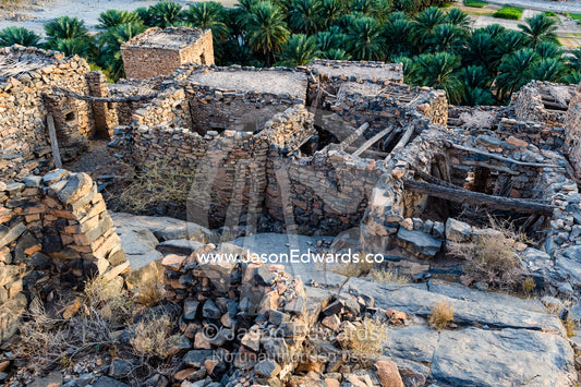 Ancient handmade stone buildings, shops and homes line a street in an abandoned village. Wadi Nakhar, Al Hamra, Ad Dakhiliyah Region, Sultanate of Oman.