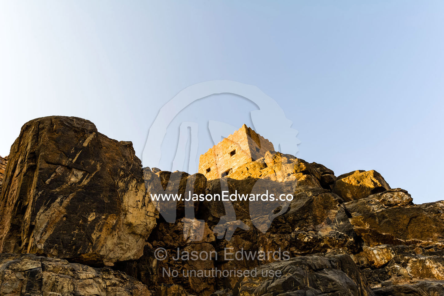 An ancient handmade stone watchtower atop a cliff in an abandoned mountain desert village. Wadi Nakhar, Al Hamra, Ad Dakhiliyah Region, Sultanate of Oman.