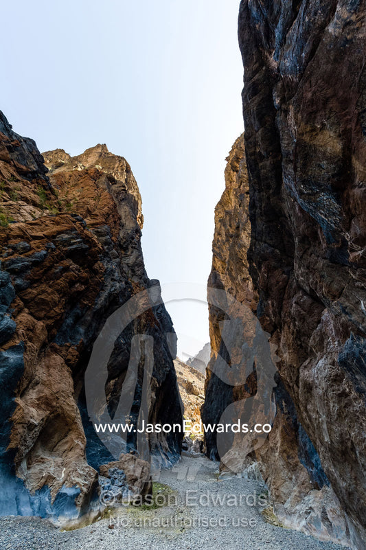 Erosion has carved a deep gorge in a desert mountain pass. Wadi Bani Awf, Snake Gorge, Western Hajar Mountains, Ad Dakhiliyah Region, Sultanate of Oman.