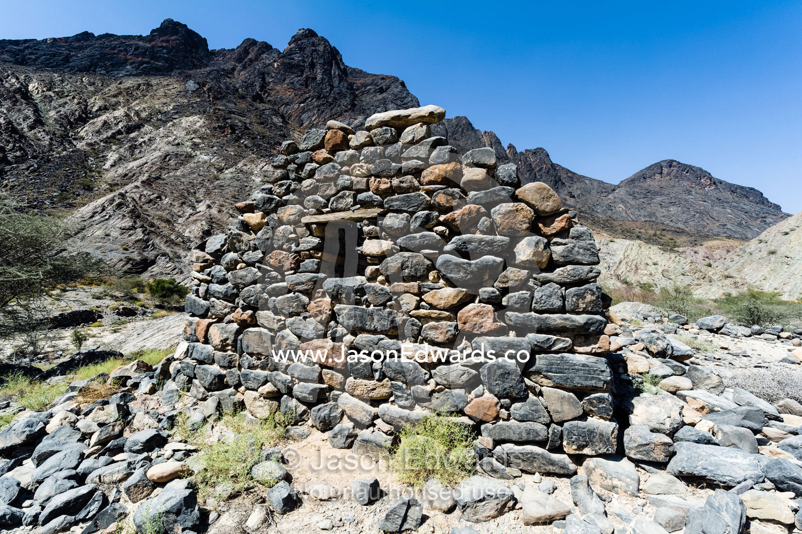The ruins of a handmade stone house in an arid desert valley. Wadi Bani Awf, Snake Gorge, Western Hajar Mountains, Ad Dakhiliyah Region, Sultanate of Oman.