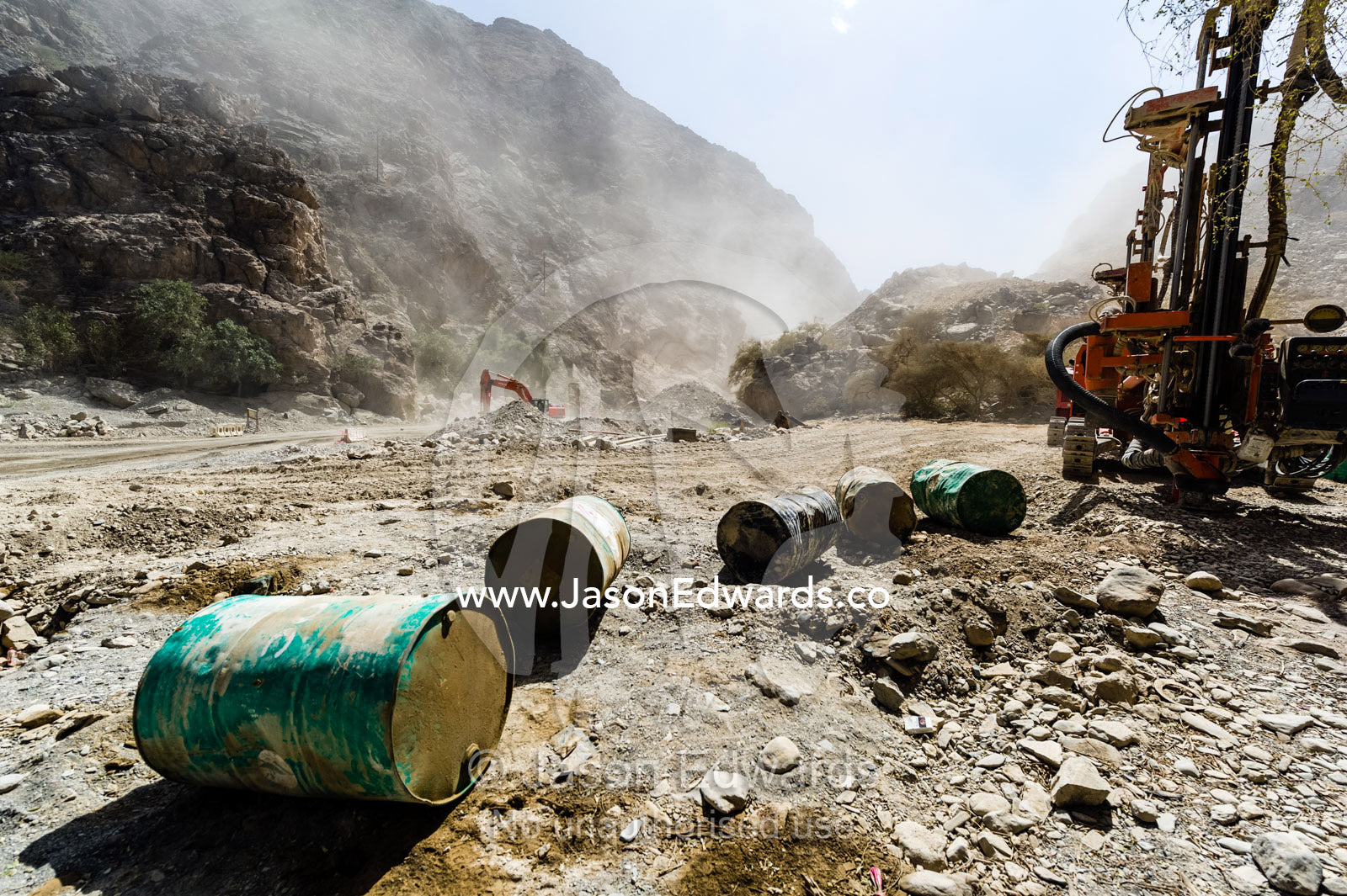 Oil drums and road construction machinery in a dusty desert gorge. Wadi Bani Awf, Snake Gorge, Western Hajar Mountains, Ad Dakhiliyah Region, Sultanate of Oman.