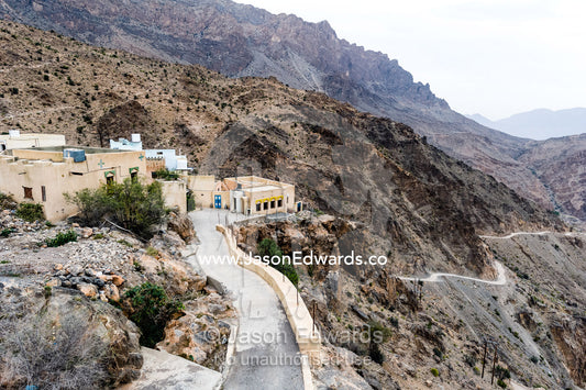 A village perched on a mountaintop overlooking an arid desert valley. Wakan Village, Wadi Mastal, Wilayt Nakhal, Al Batinah South Governorate, Sultanate of Oman.