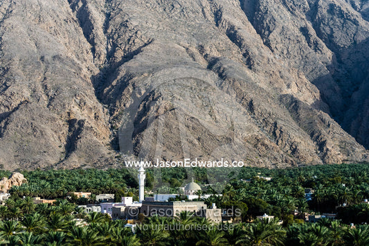 The minaret of a mosque rises above a plantation of date palm trees. Wilayt Nakhal, Mount Nakhal, Al Batinah South Governorate, Sultanate of Oman.