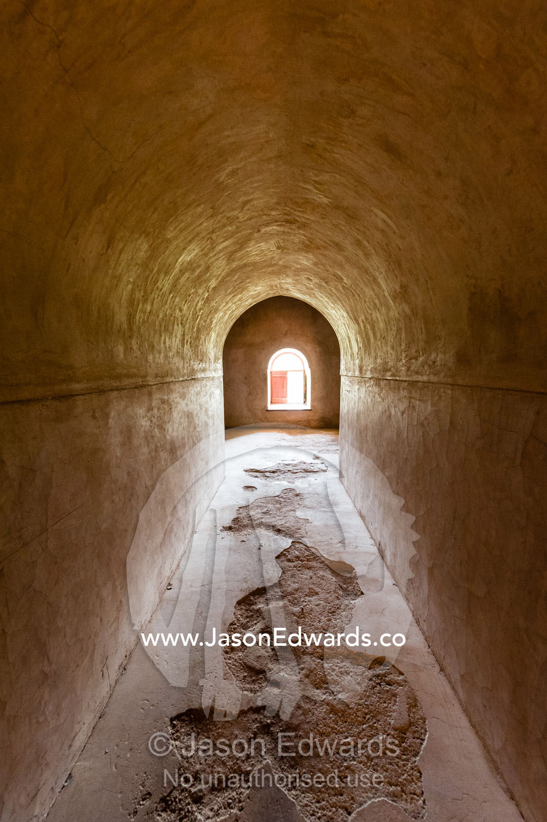 Sunlight illuminates the stone of a polished arched tunnel roof. Nakhal Fort, Wilayt Nakhal, Mount Nakhal, Al Batinah South Governorate, Sultanate of Oman.