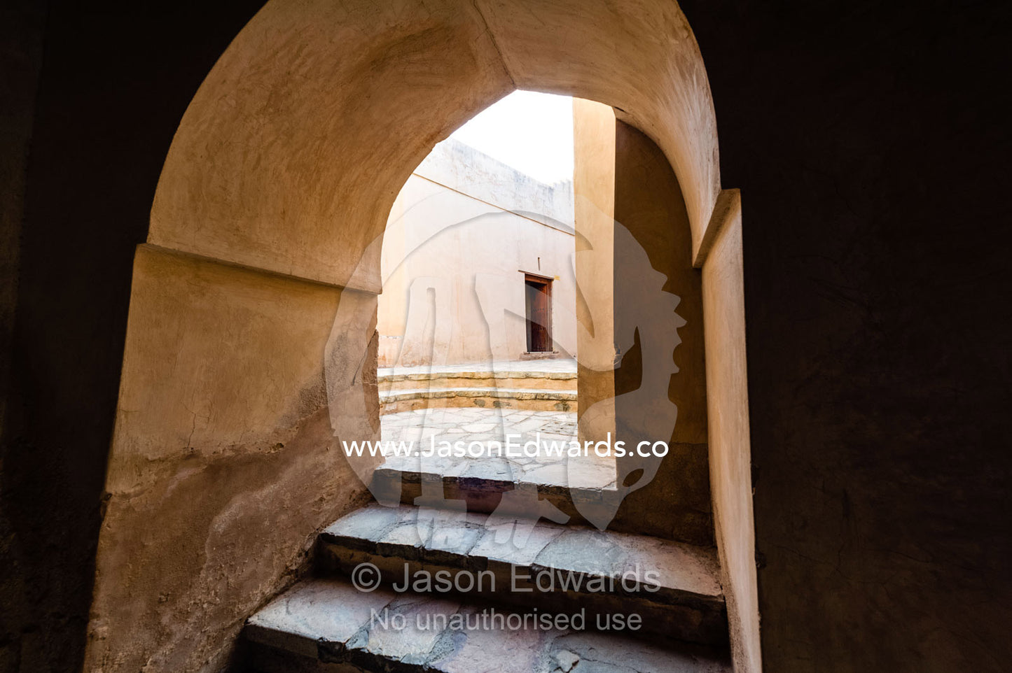 A stairway leads through a deep stone archway into a courtyard. Nakhal Fort, Wilayt Nakhal, Mount Nakhal, Al Batinah South Governorate, Sultanate of Oman.