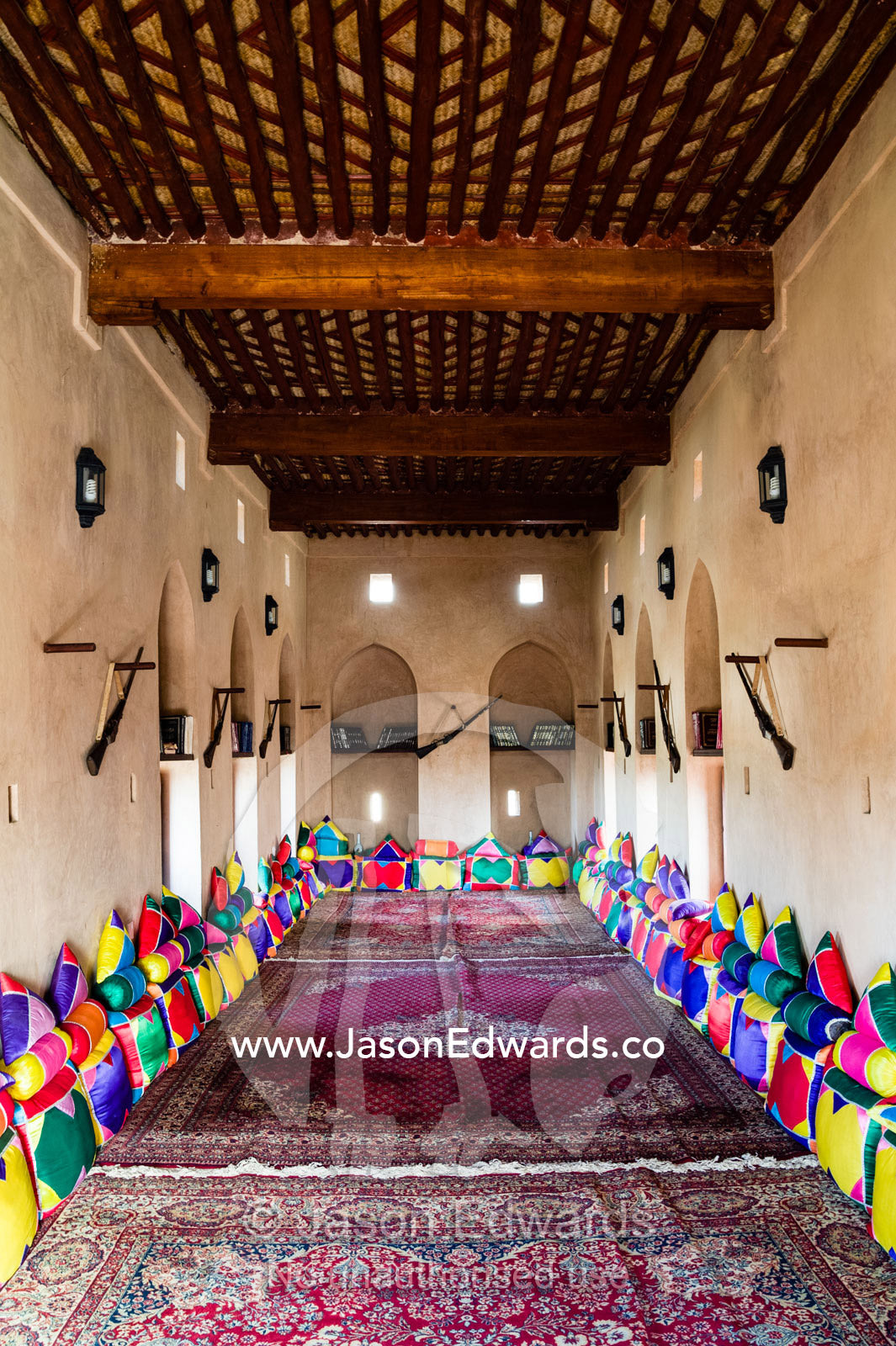 Colorful cushions and carpets line the Majlis an assembly room in Nakhal Fort. Nakhal Fort, Wilayt Nakhal, Mount Nakhal, Al Batinah South Governorate, Sultanate of Oman.