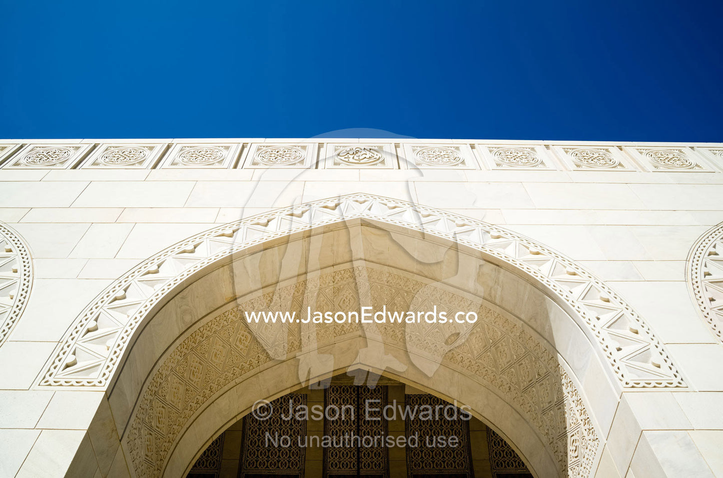 Carvings in the white sandstone of an archway lintel at the Grand Mosque. Sultan Qaboos Grand Mosque, Muscat, Sultanate of Oman.