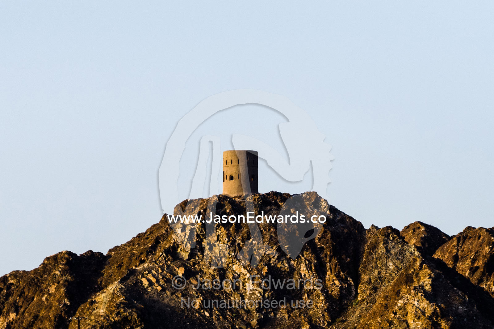 An ancient watchtower on a desert mountaintop overlooking the Gulf of Oman. Muscat, Gulf of Oman, Sultanate of Oman.