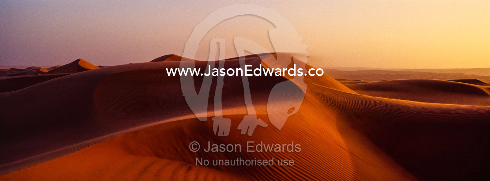 Sunset shines on sand dunes in the desert. Wahiba Sands, Ramlat al-Wahiba, Sharqiya Sands, Sultanate of Oman.