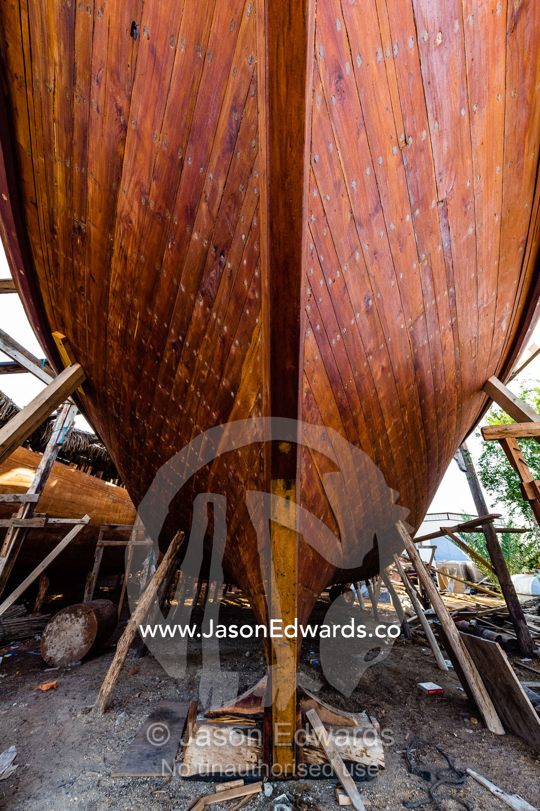 Nail holes filled with putty and freshly oiled timber hull planks on a dhow under construction. Sur, Ash Sharqiyah Region, Gulf of Oman, Sultanate of Oman.