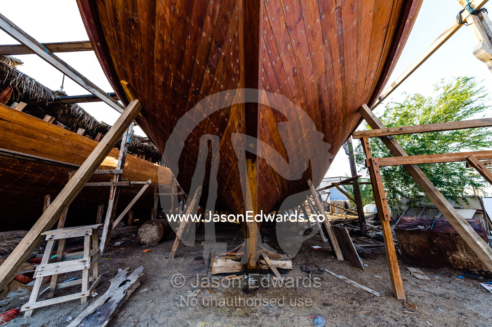 Nail holes filled with putty and freshly oiled timber hull planks on a dhow under construction. Sur, Ash Sharqiyah Region, Gulf of Oman, Sultanate of Oman.