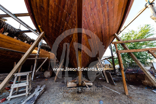 Nail holes filled with putty and freshly oiled timber hull planks on a dhow under construction. Sur, Ash Sharqiyah Region, Gulf of Oman, Sultanate of Oman.