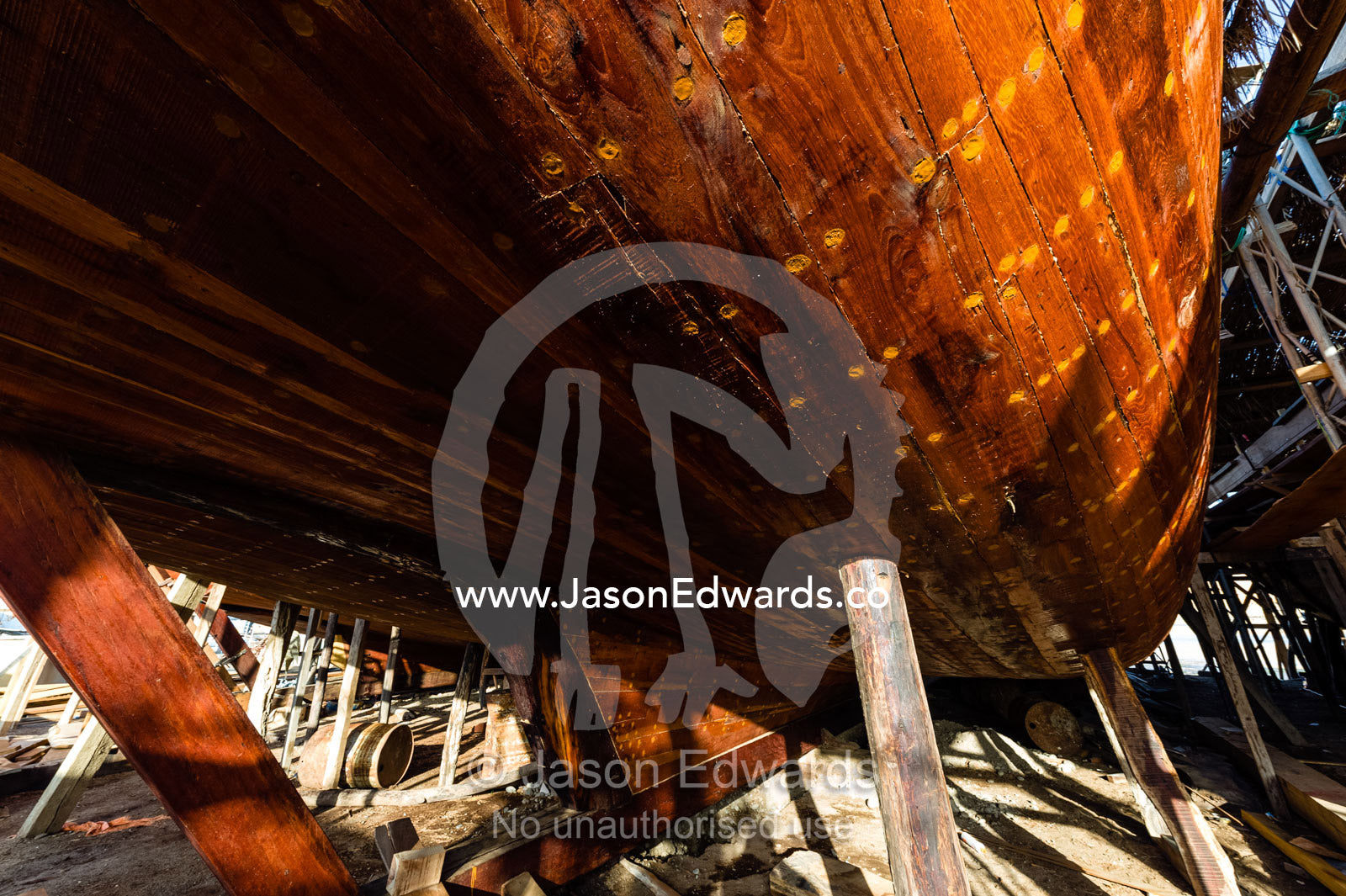 Nail holes filled with putty and freshly oiled timber hull planks on a dhow under construction. Sur, Ash Sharqiyah Region, Gulf of Oman, Sultanate of Oman.