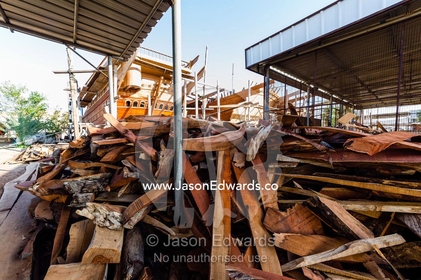 A pile of timber scraps from the construction of ancient dhows in a ship building yard. Sur, Ash Sharqiyah Region, Gulf of Oman, Sultanate of Oman.