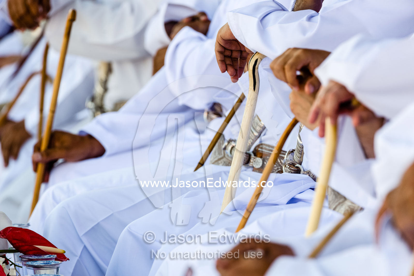 Muslim elders holding ceremonial canes while they watch camel racing in the desert. Bidiya, Sharqiya Region, Sultanate of Oman.
