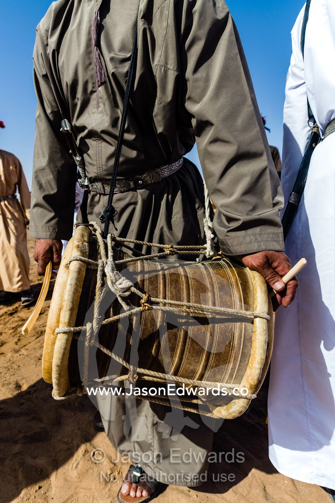 A double-sided skin and rope drum known as a mirwas played by a band at a camel race. Bidiya, Sharqiya Region, Sultanate of Oman.