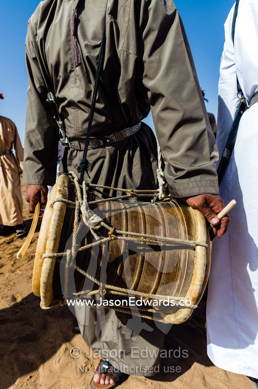 A double-sided skin and rope drum known as a mirwas played by a band at a camel race. Bidiya, Sharqiya Region, Sultanate of Oman.