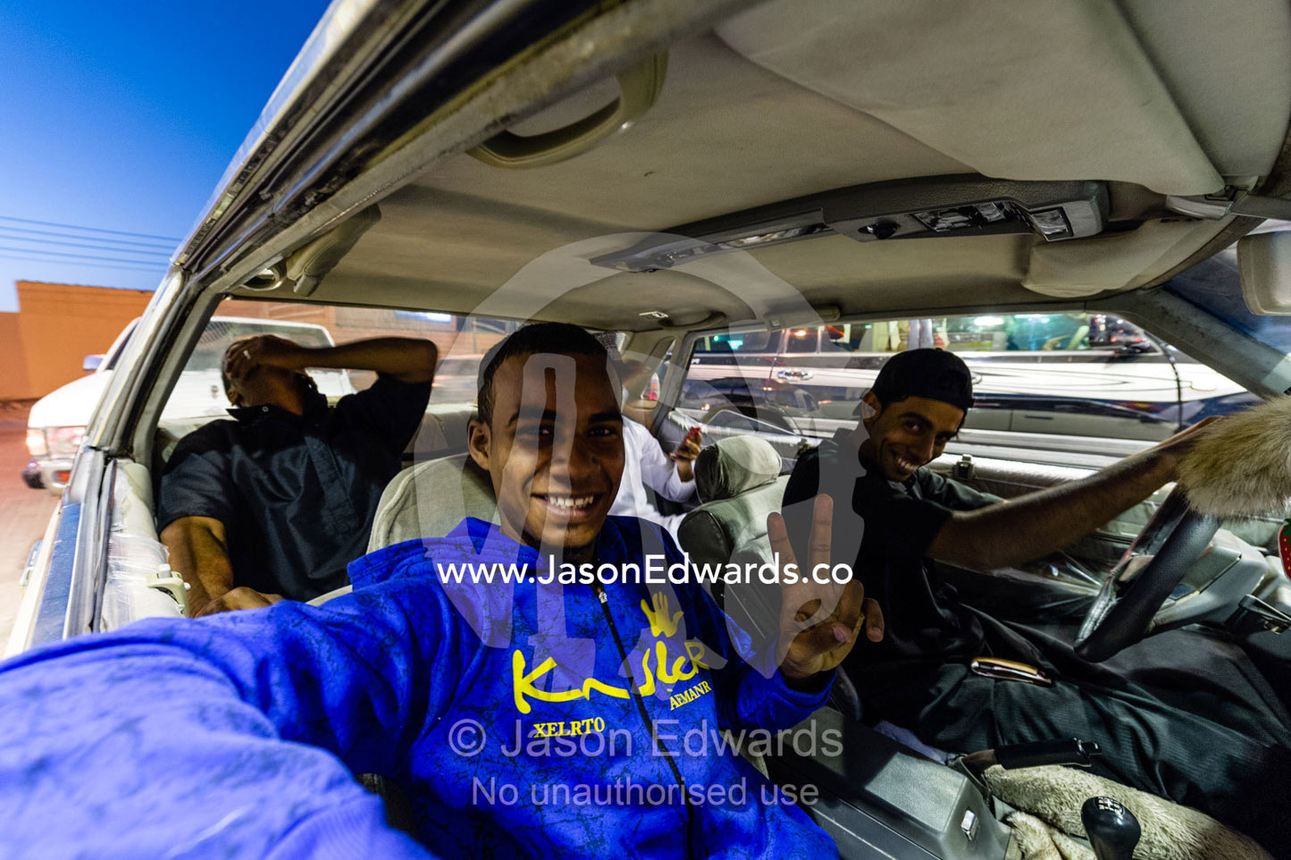 A group of young Muslim men putting fuel in their car to have fun on a Saturday night. Al Hamra, Ad Dakhiliyah Region, Sultanate of Oman.
