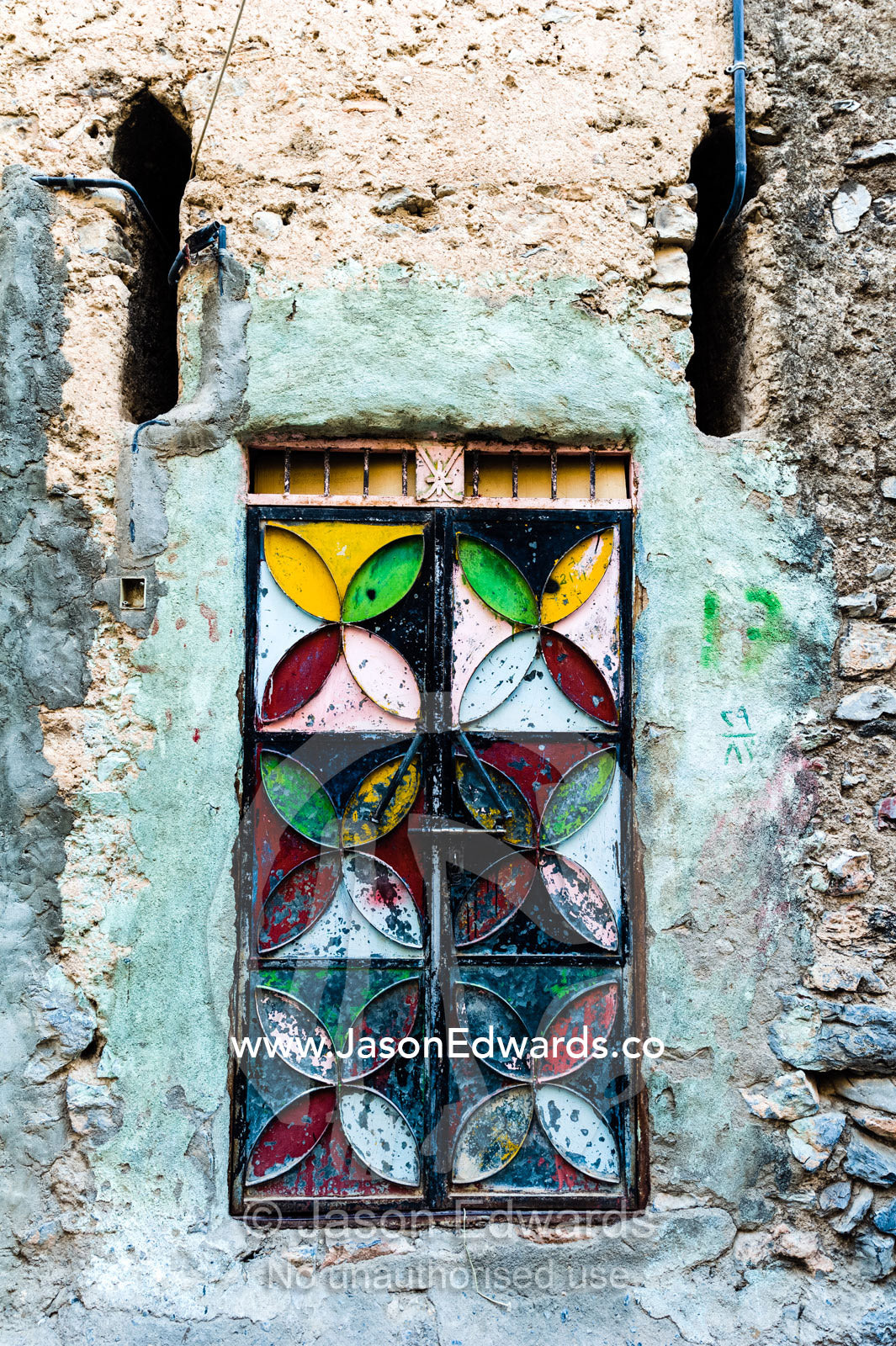 A painted and decorated steel door in an ancient mud brick village. Misfat Al Abryeen, Al Hajar Mountains, Al Hamra, Ad Dakhiliyah Region, Sultanate of Oman.