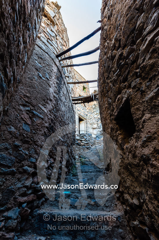 Stone steps through a narrow mud brick alleyway in an ancient mud brick village in the desert. Misfat Al Abryeen, Al Hajar Mountains, Al Hamra, Ad Dakhiliyah Region, Sultanate of Oman.