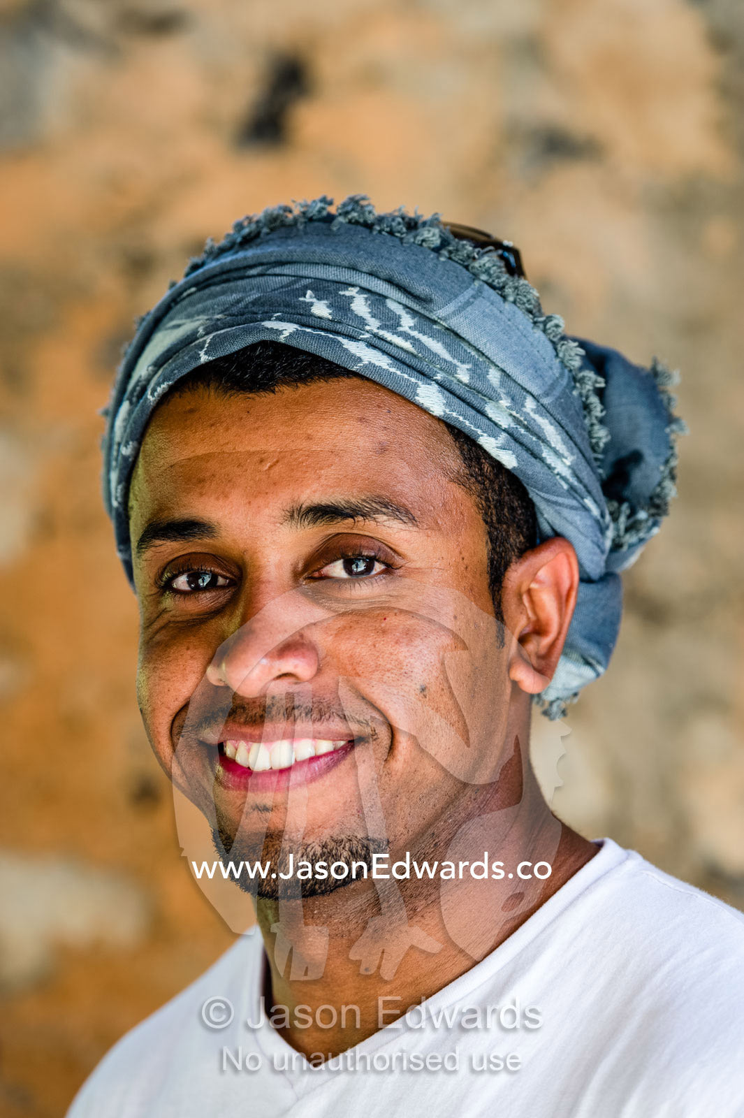 A handsome and happy smiling Muslim man wearing a traditional masar. Misfat Al Abryeen, Al Hajar Mountains, Al Hamra, Ad Dakhiliyah Region, Sultanate of Oman.