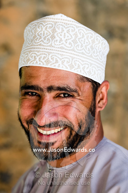 A handsome and happy smiling Muslim man wearing a traditional kuma. Misfat Al Abryeen, Al Hajar Mountains, Al Hamra, Ad Dakhiliyah Region, Sultanate of Oman.