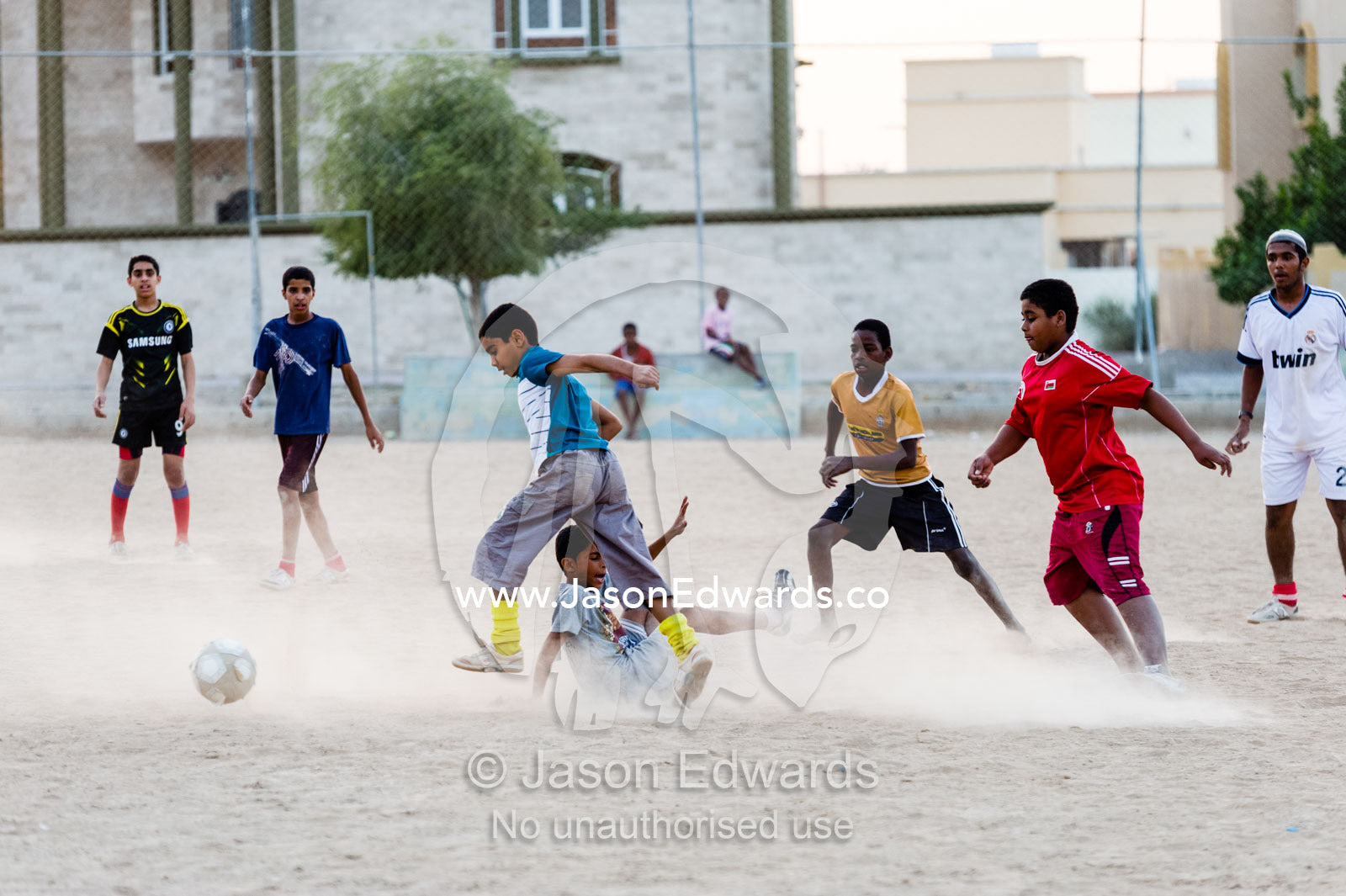 Young boys play a rough and competitive game of football on a dusty pitch. Nakhal Fort, Wilayt Nakhal, Mount Nakhal, Al Batinah South Governorate, Sultanate of Oman.