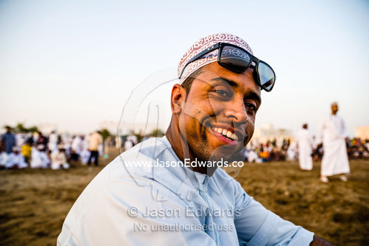A Muslim man wearing a traditional kuma and sunglasses at a bullfight. Al Sharadi, Seeb, Muscat, Sultanate of Oman.