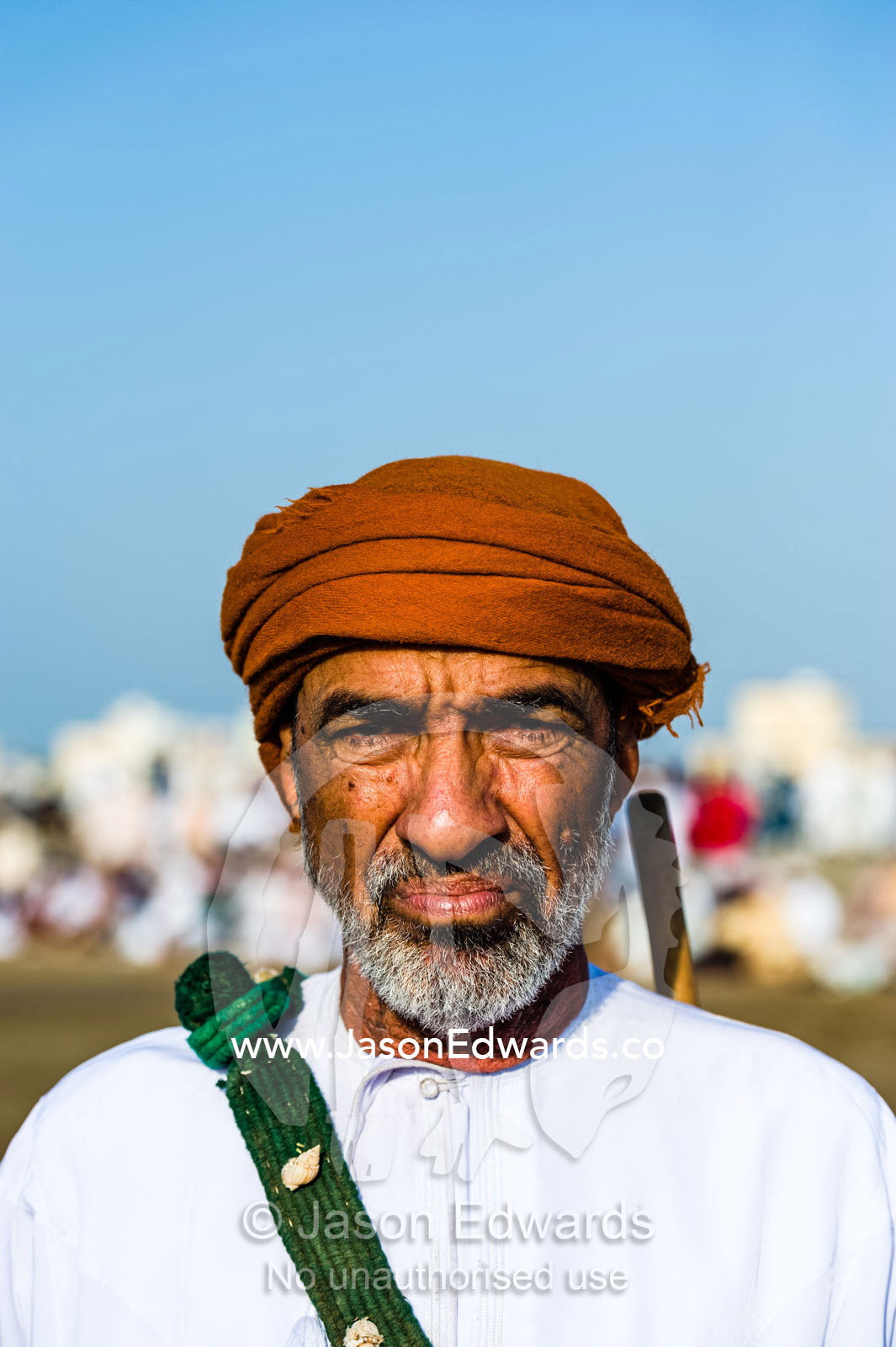 A man wearing a traditional masar and dishdasha at a bull fight. Al Sharadi, Seeb, Muscat, Sultanate of Oman.