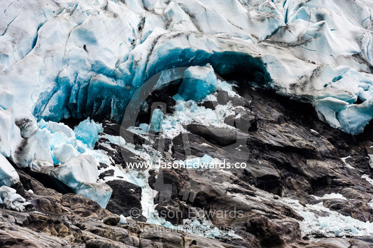 A jagged glacier tongue recedes up a rugged and inhospitable mountain in a fiord. Fjord of Eternity, Maniitsoq, Sukkertoppen, Qeqqata Municipality, Greenland.
